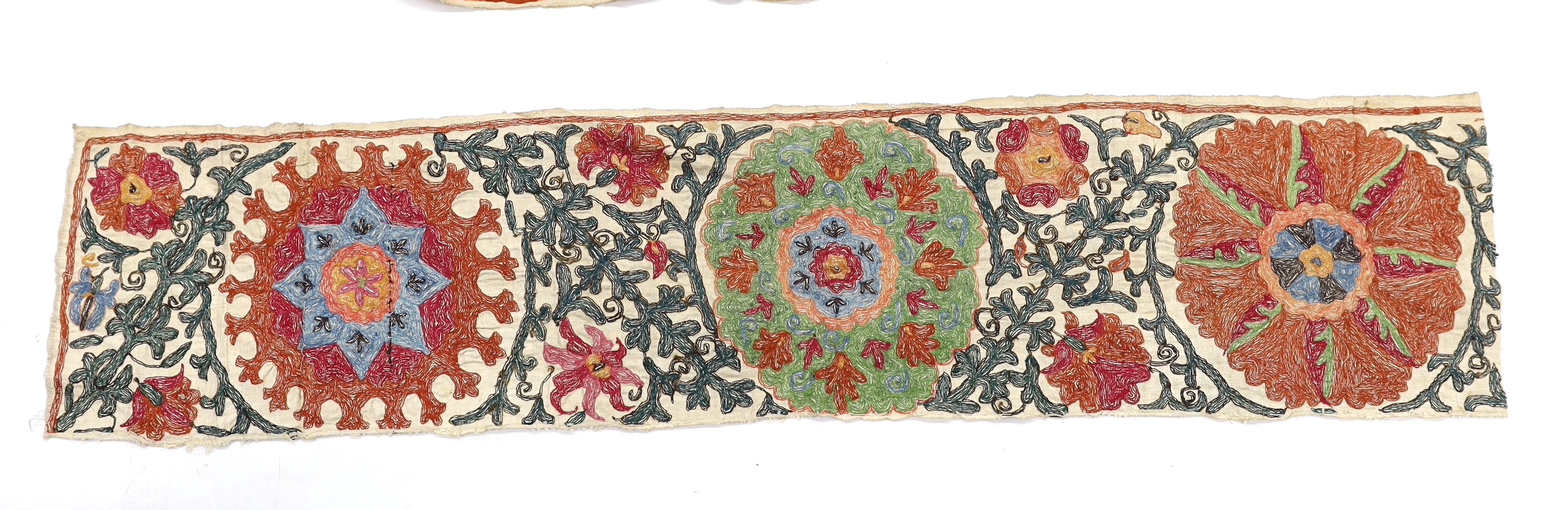 Four early 20th century Uzbek Suzani panels, embroidered with hand dyed silk on thick woven linen, in large brightly multi-coloured symbolic motifs, possibly embroidered for a larger prayer rug or hanging, longest 125cm